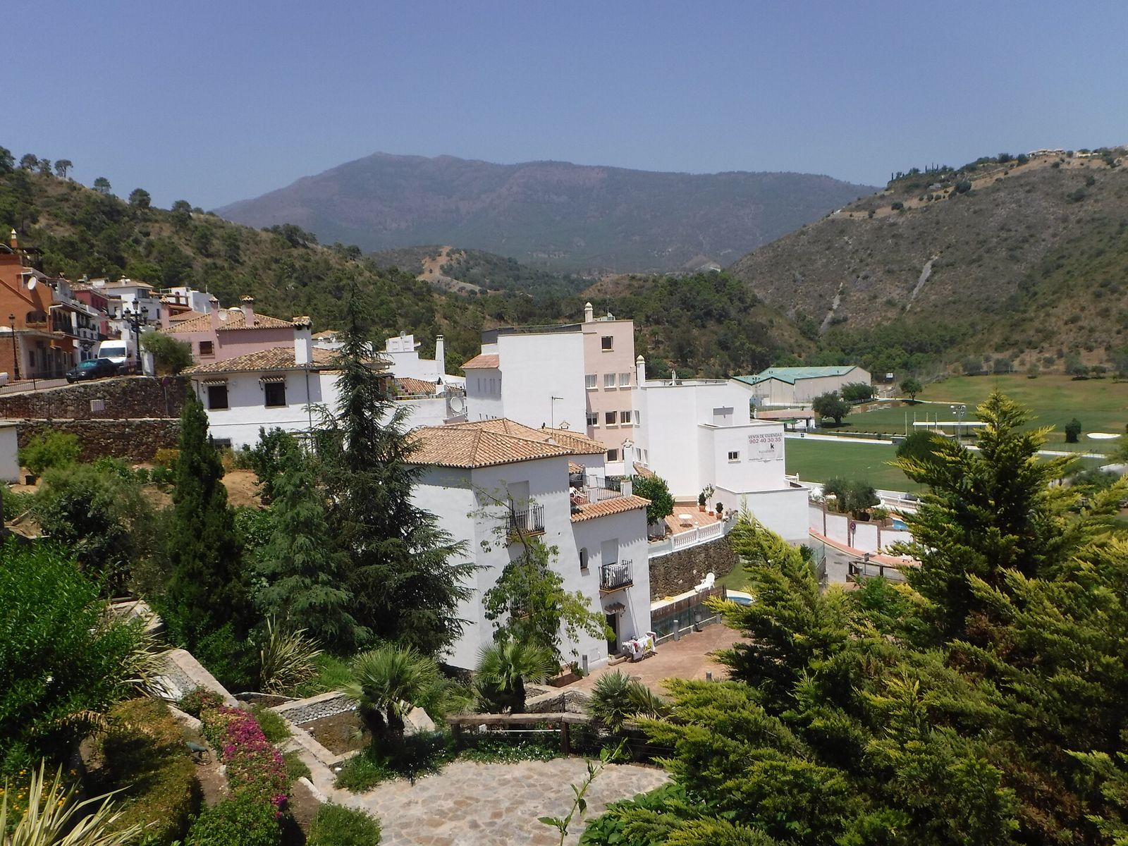 White houses of Benahavís village against green hills