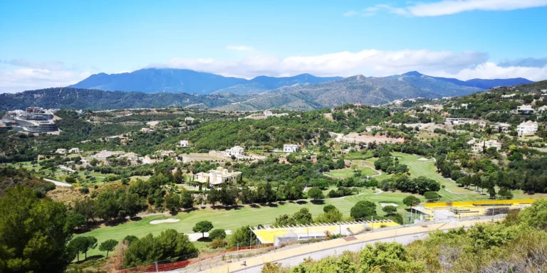 Valley of villas, trees and golf fairways below a mountain range