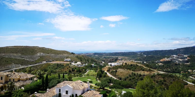 Tiled roofs in the foreground, with the green valley and distant hills beyond